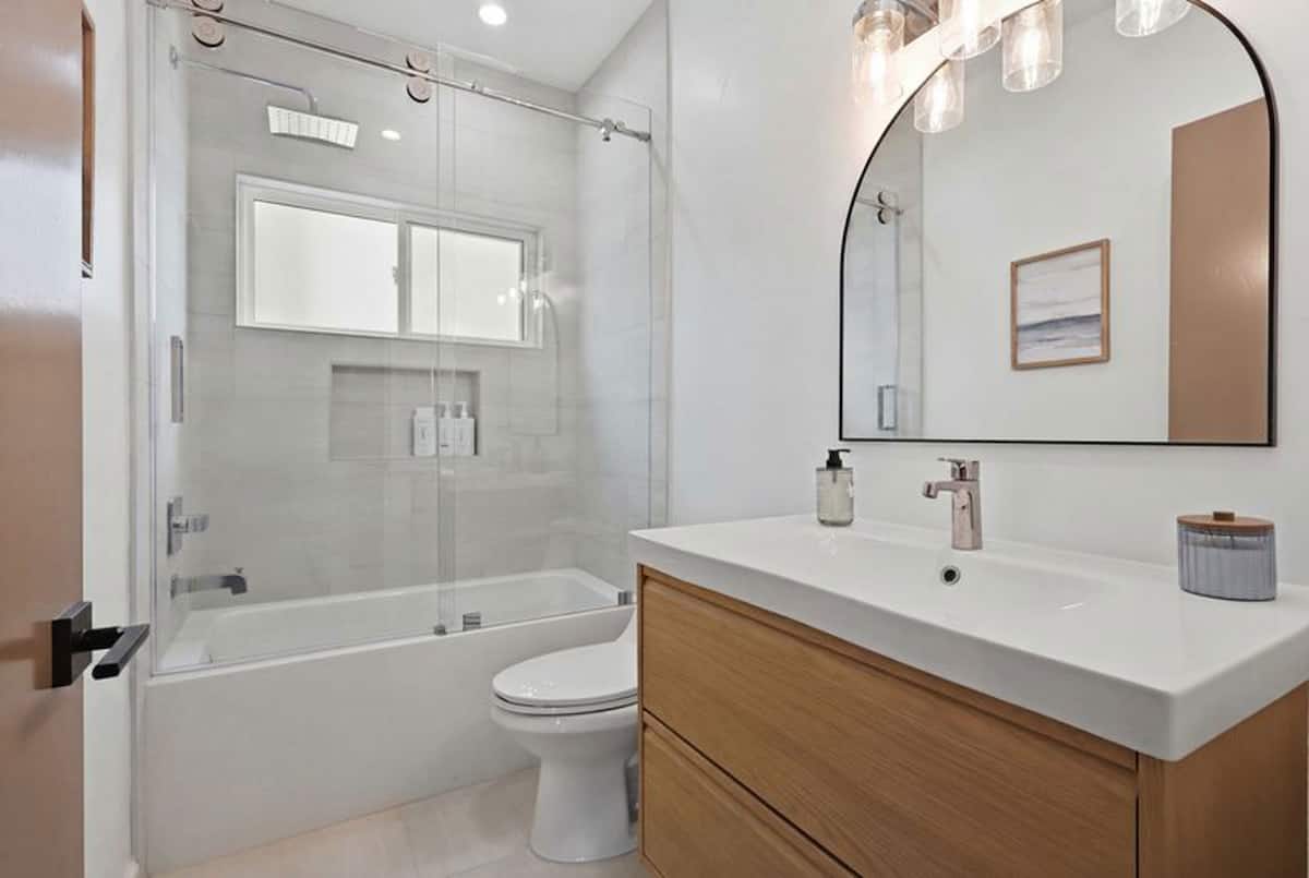 Guest Suite No. 3 bathroom, with a tub and shower behind sliding glass