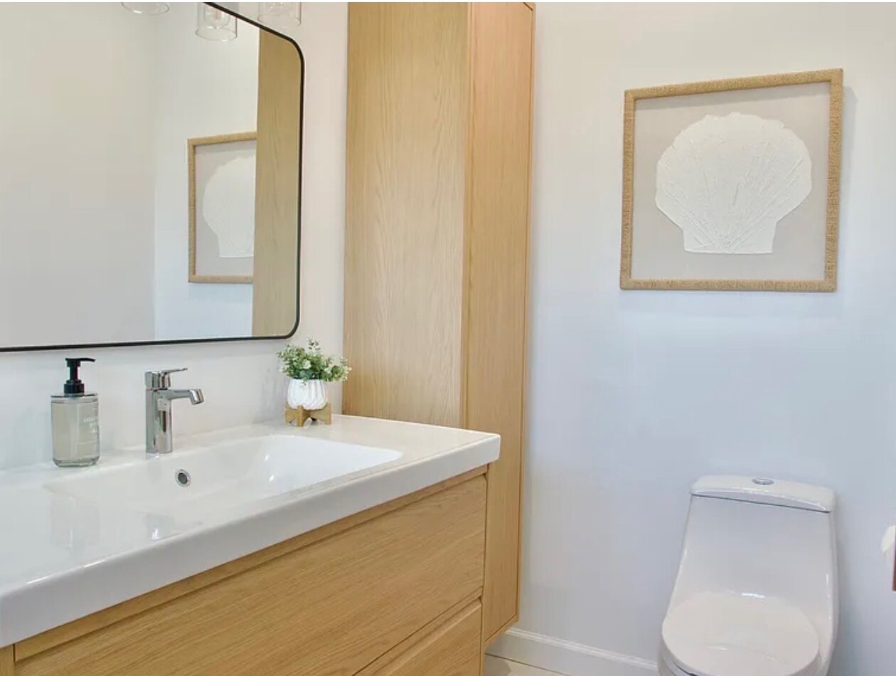 Guest Suite No. 2 bathroom vanity, with a light oak linen tower and shell artwork