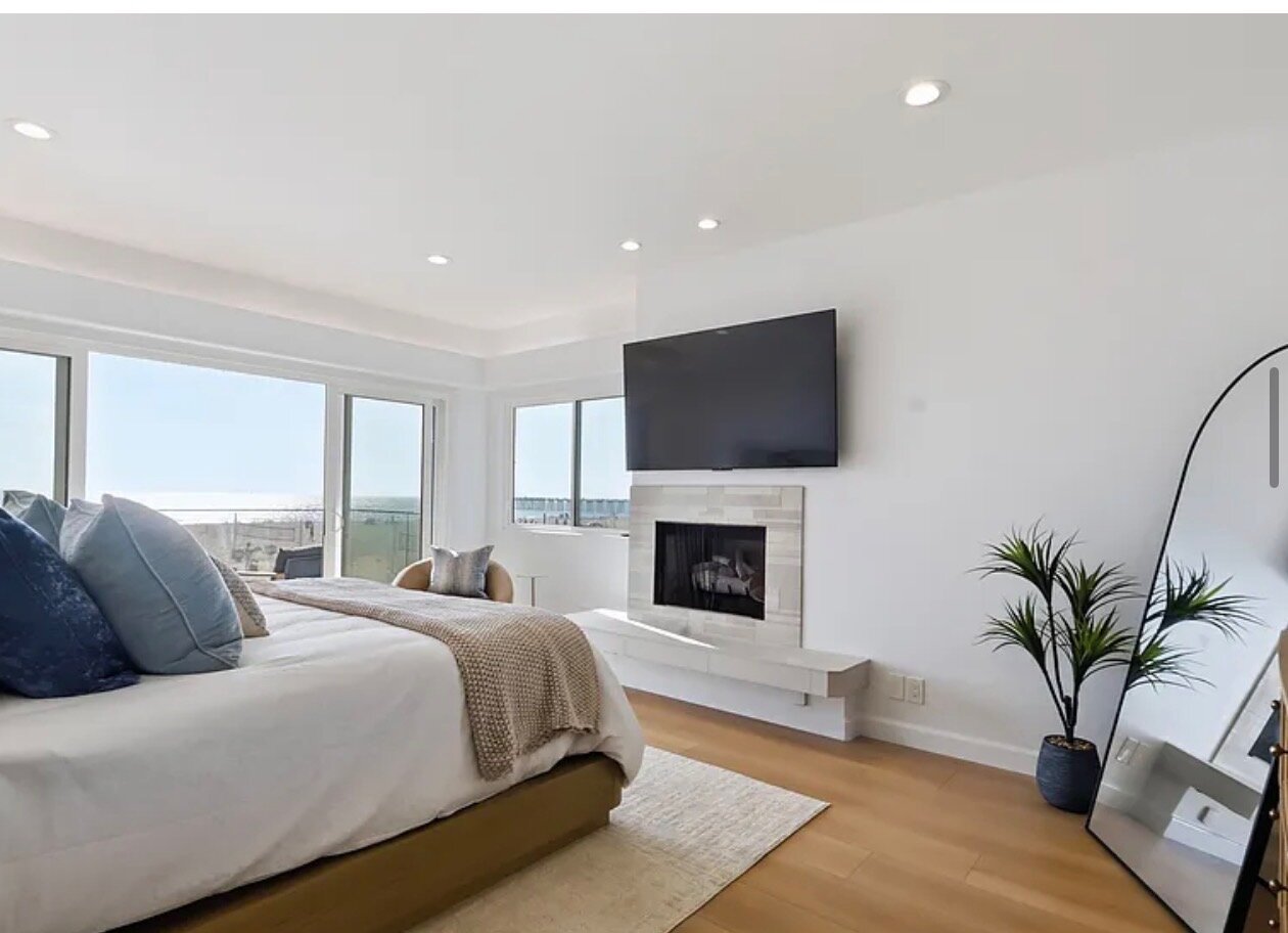 Primary suite fireplace and windows toward the ocean